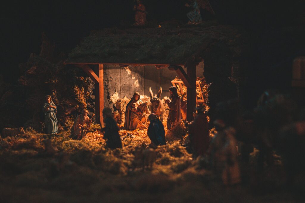 A detailed and festive nativity scene showcasing handcrafted figurines illuminated softly at night.