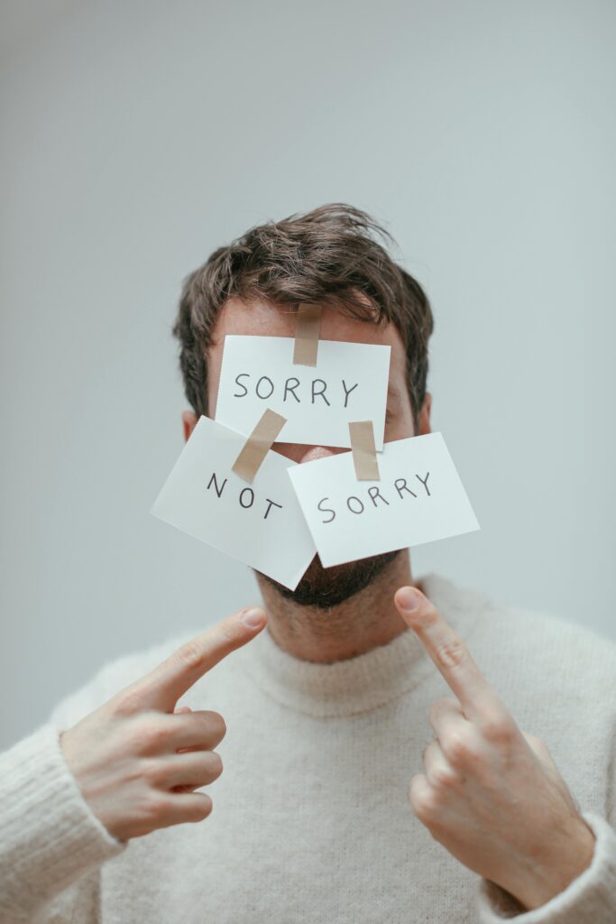 Portrait of a man with 'Sorry Not Sorry' notes taped to his face.