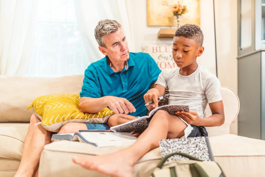 Father and son engaged in a teaching moment at home, promoting education and family bonding.
